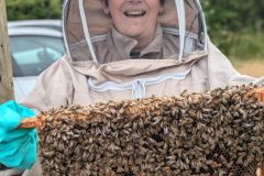 "All Smiles and Bees"The perfect combination of curiosity and joy, this beekeeper enjoys the magic of beekeeping one frame at a time.